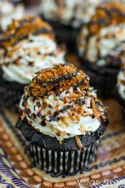 Easy Samoa Cupcakes - Chocolate cake topped with brown sugar frosting, toasted coconut, chocolate syrup and a Samoa cookie | JavaCupcake.com