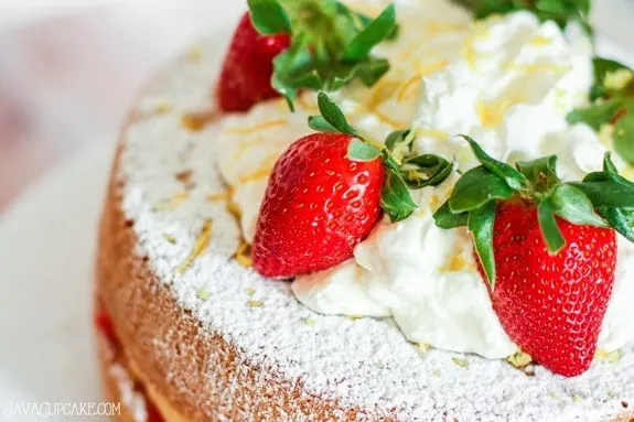 Victoria Sponge sandwich cake with vanilla pudding & fresh strawberry filling topped with fresh whipped cream, lemon zest and more strawberry! | JavaCupcake.com