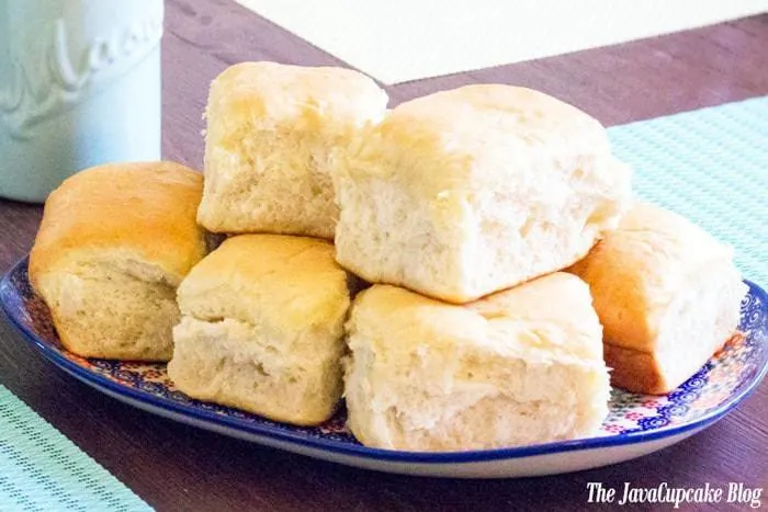 Homemade yeast dinner rolls covered in warm, melted butter. The perfect side dish to any meal! | The JavaCupcake Blog https://javacupcake.com