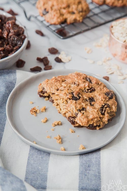 peanut butter oatmeal cookie on a plate in a kitchen with a bowl of raisins 