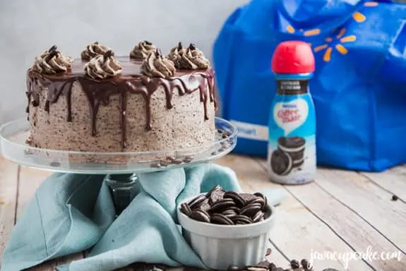 mocha cookies and cream cake on a stand with a bowl of cookies