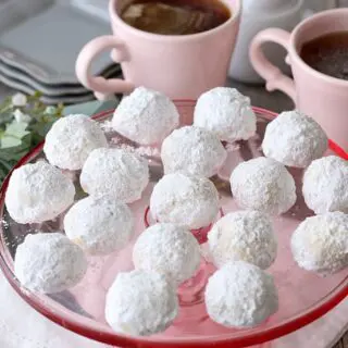 Russian tea cake balls served on top of a pink cake stand for visiting guests.