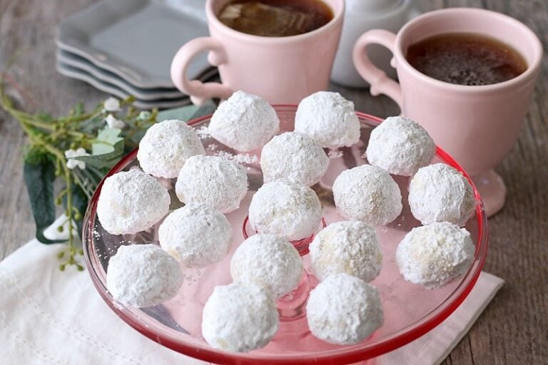 Russian tea cake balls served on top of a pink cake stand for visiting guests.